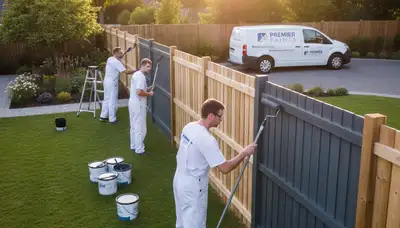 Professional fence painters staining wood fence in Wellesley MA for lasting weather protection
